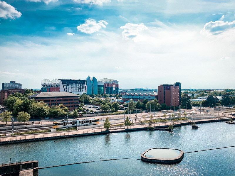 A summer day, showing the river and some buildings at Old Trafford.