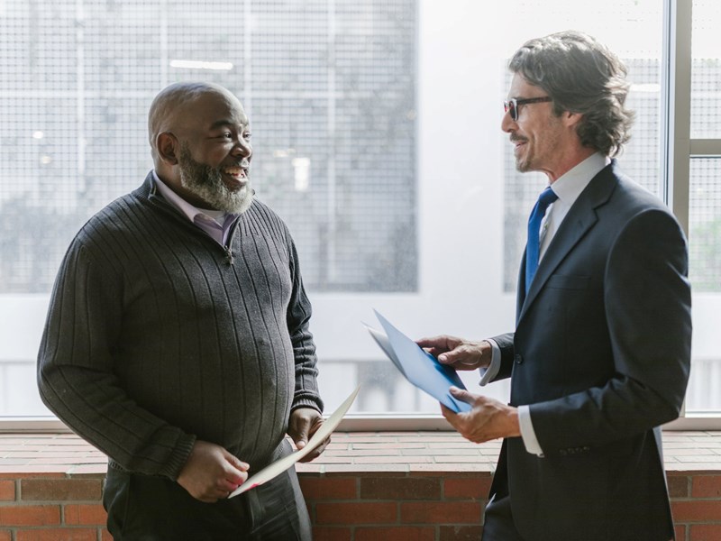 Two men conversing happily in office space