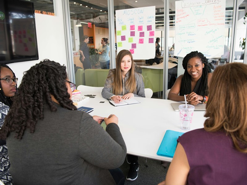 A group of people working together around a desk